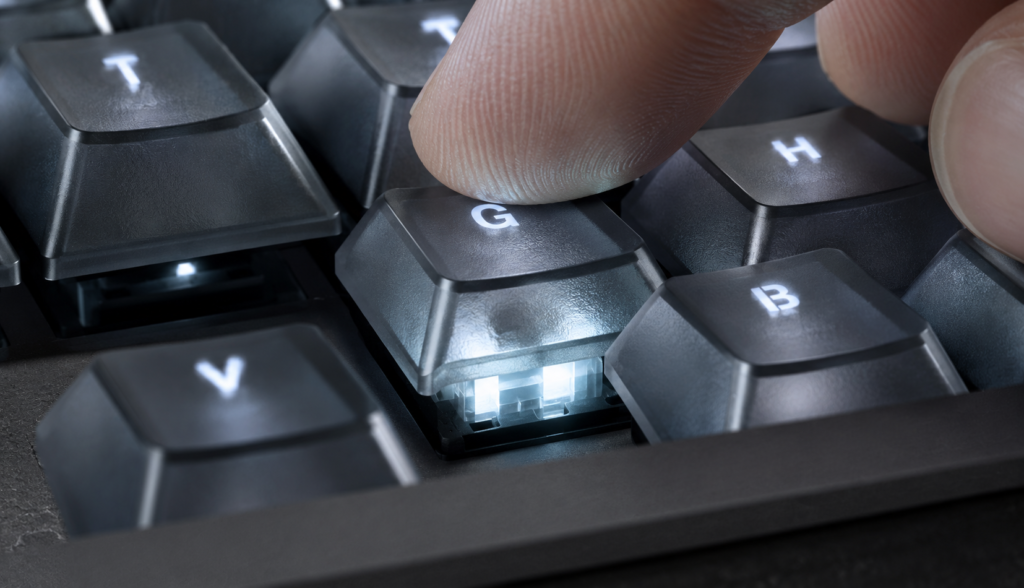Close up macro shot of finger pressing illuminated mechanical keyboard key