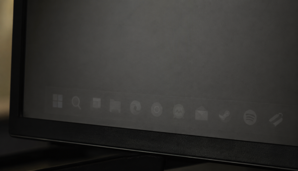 Close-up of OLED screen showing faint burn-in shadow of a taskbar